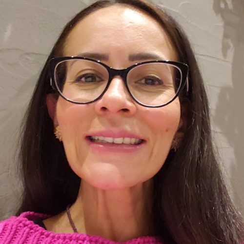 Uma mulher de óculos sorrindo